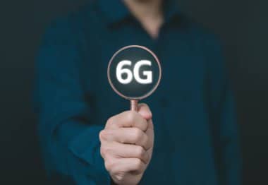 Man holding a stick displaying 6G.